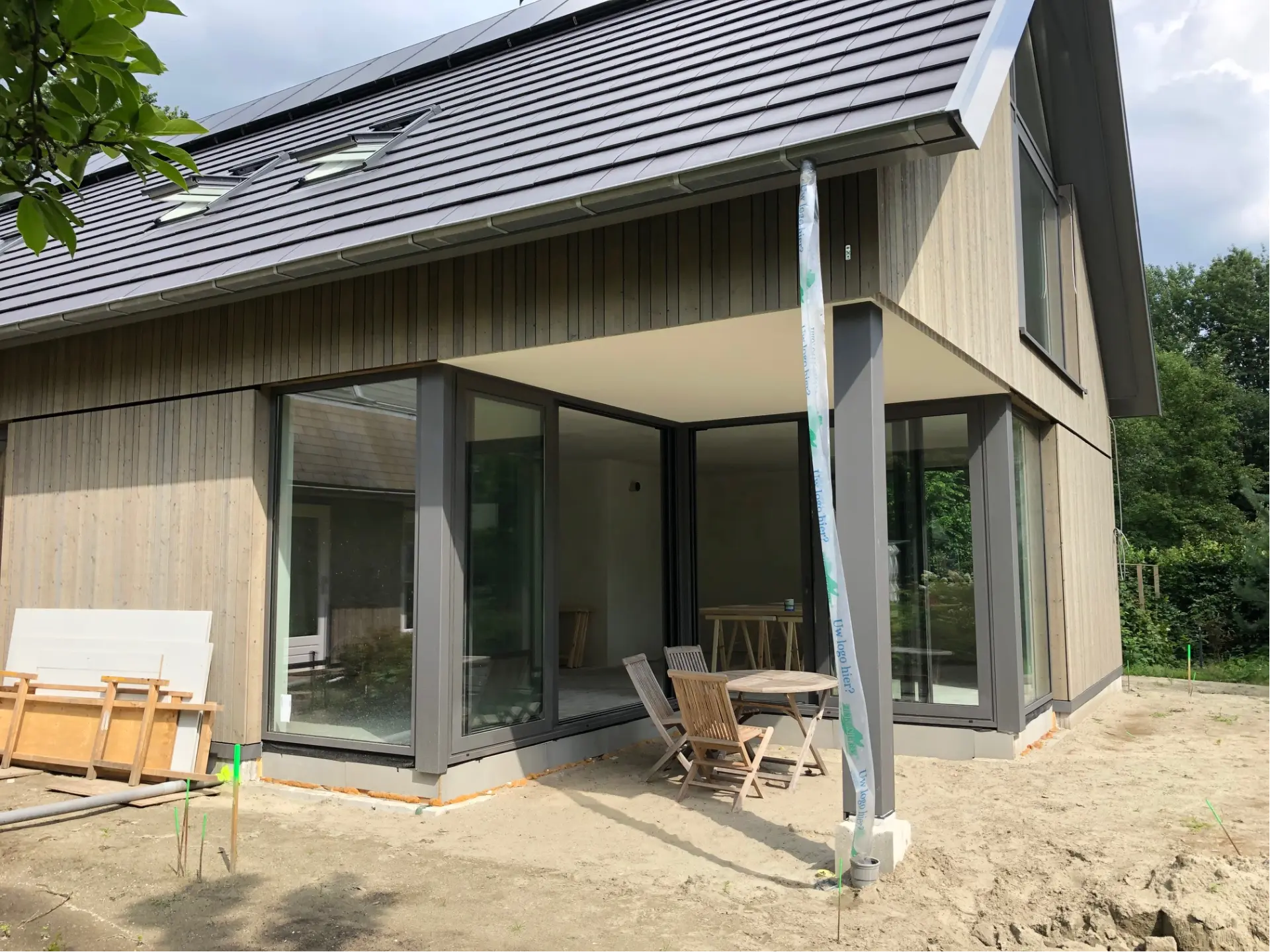 Woning met hoekpui en aluminium schuifdeuren onder een overstek