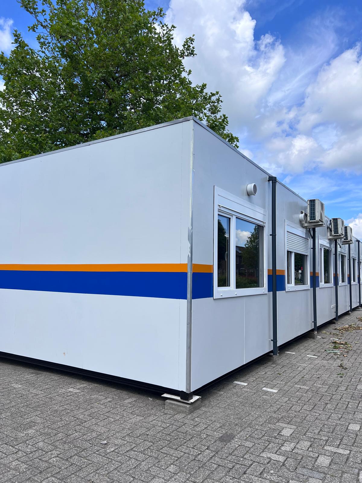 Schoolunits met blauwe en oranje belijning en airco-units