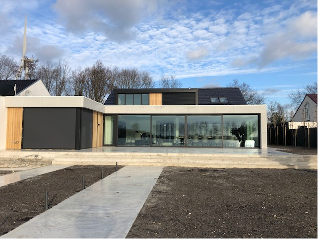 Moderne woning met grote aluminium schuifpuien en houten gevelbekleding