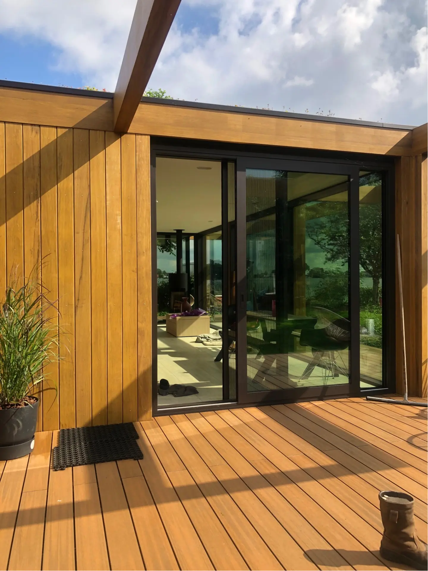Houten tuinkamer met zwarte aluminium schuifpui en vlonderterras
