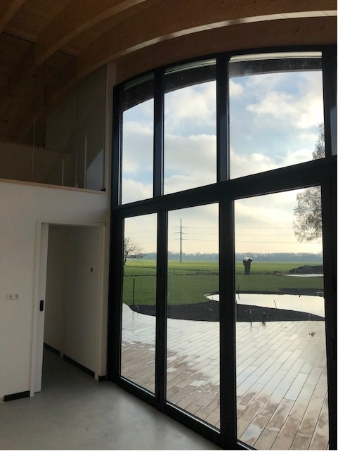 Gevel van aluminium kozijnen met glas, gezien vanuit het interieur